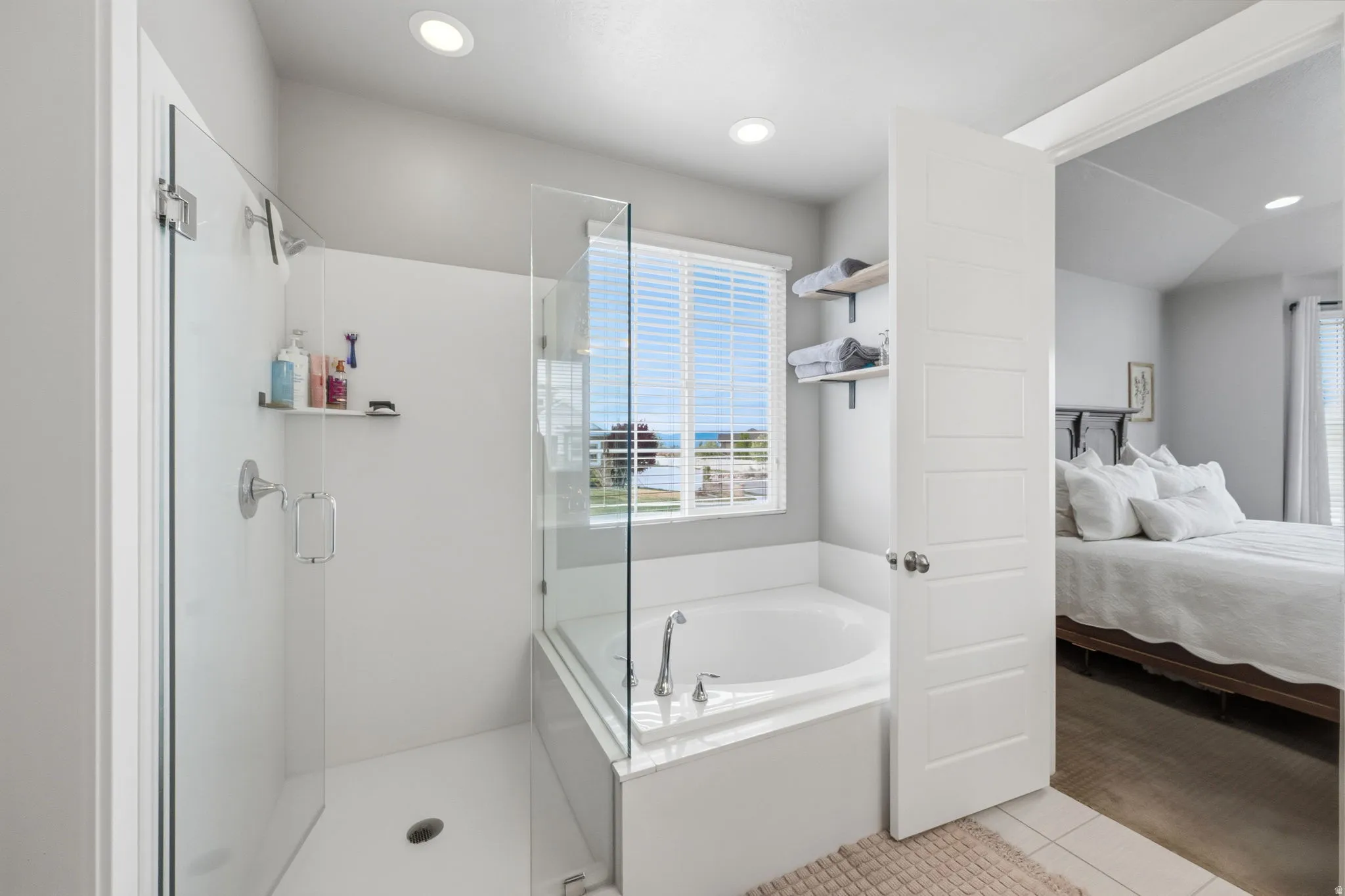 Full bath featuring a stall shower, a garden tub, connected bathroom, light tile patterned floors, and recessed lighting
