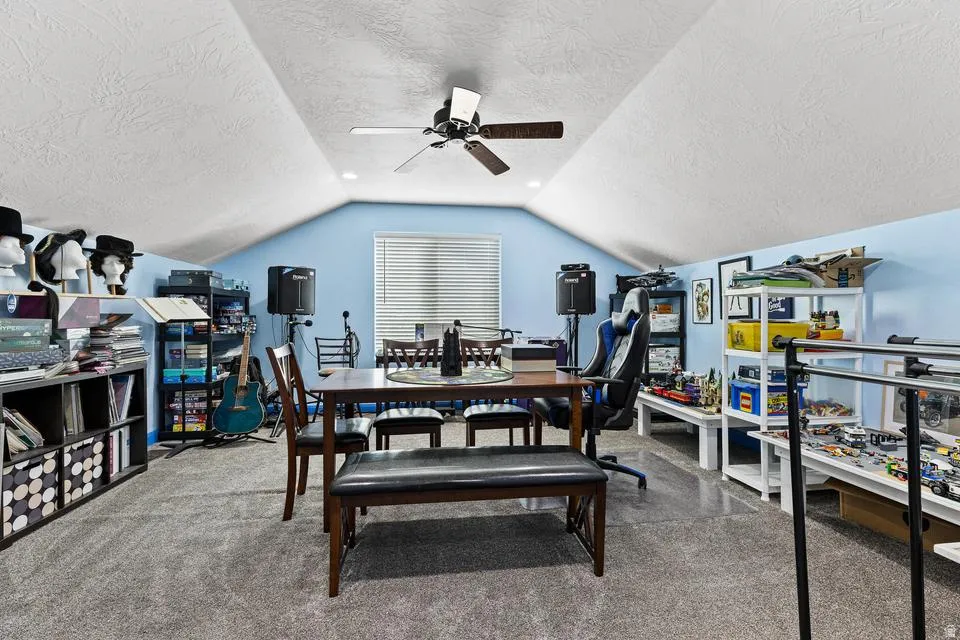 Dining area featuring a textured ceiling, carpet floors, and a ceiling fan