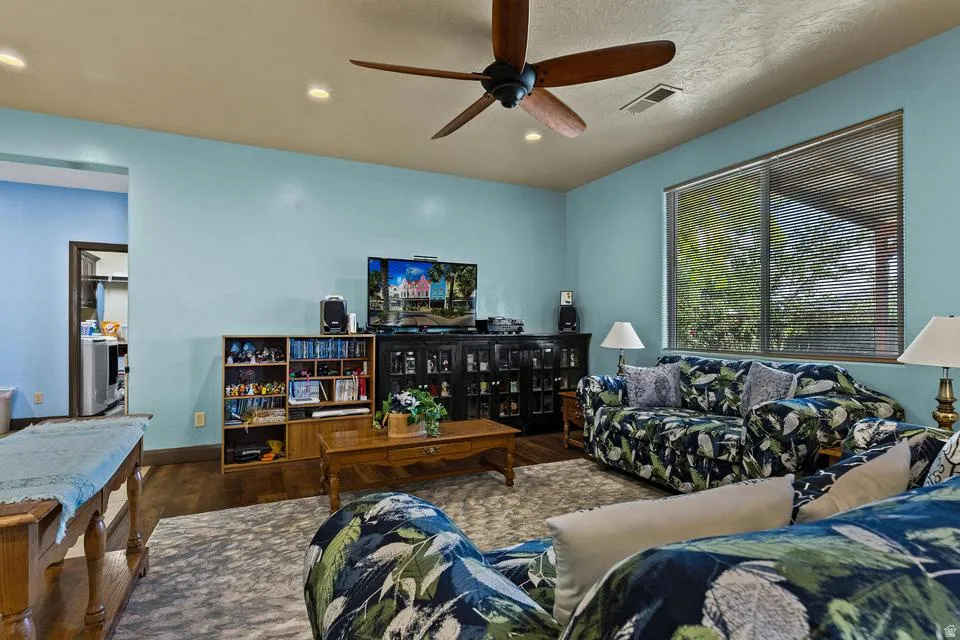 Living room featuring a ceiling fan, wood finished floors, a textured ceiling, and recessed lighting