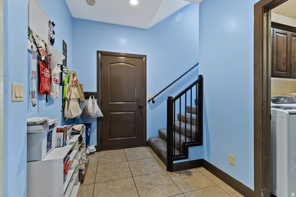 Entryway featuring washer / clothes dryer and light tile patterned floors