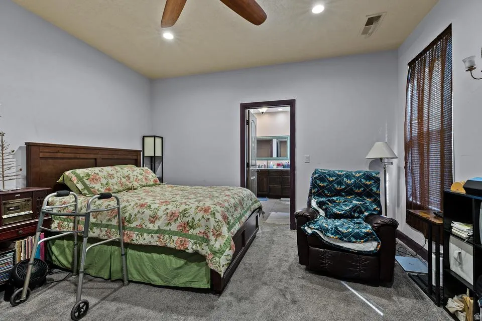 Carpeted bedroom with recessed lighting, a ceiling fan, and connected bathroom