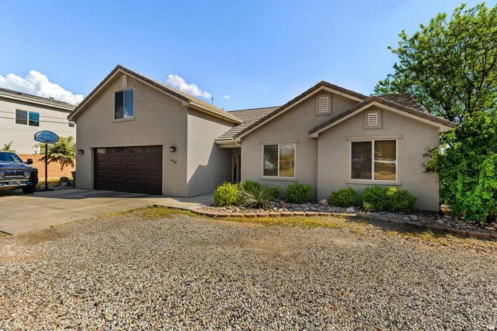 View of front of property featuring driveway, a garage, stucco siding, and a tiled roof