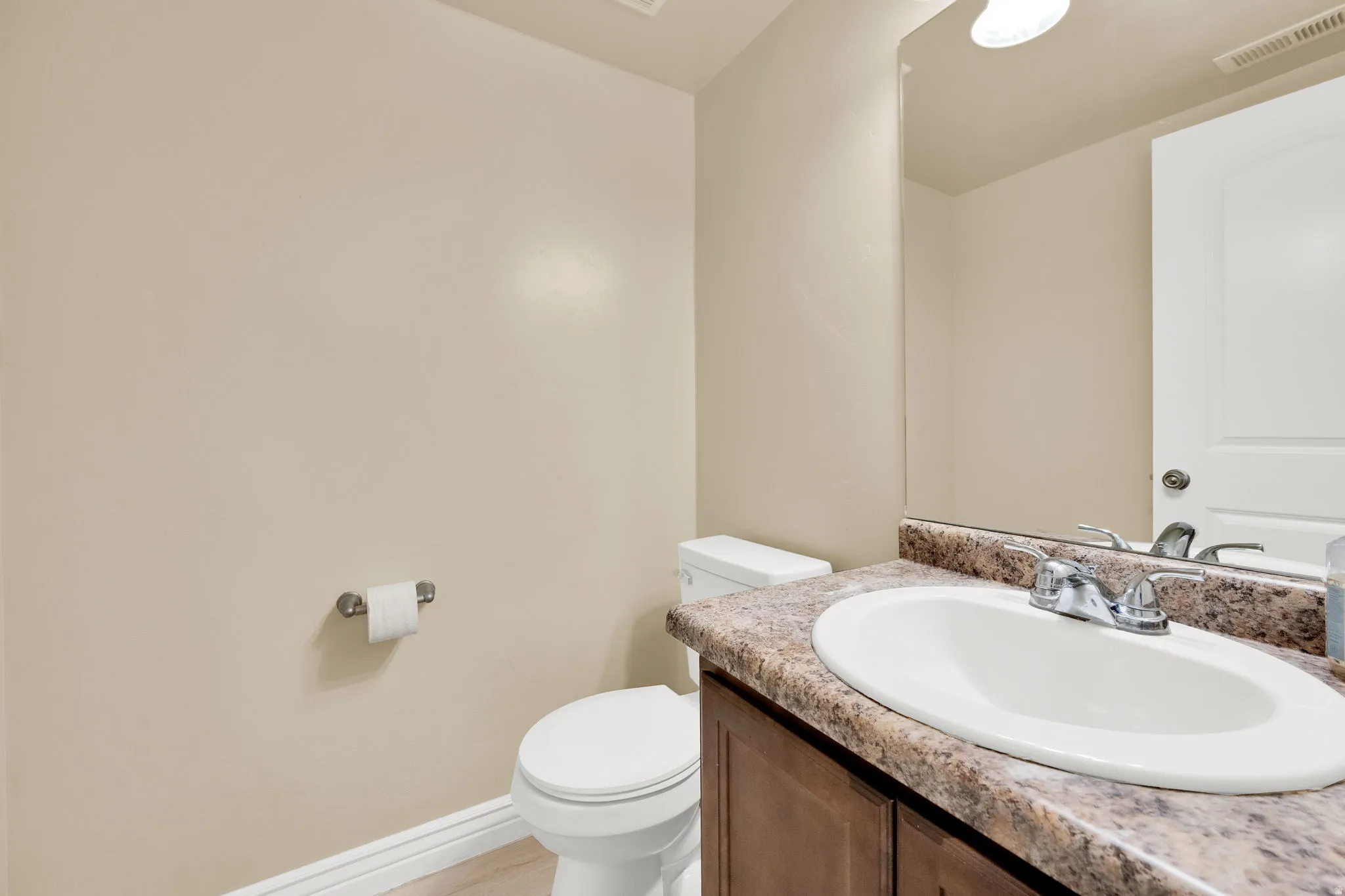 Half bath with baseboards and vanity