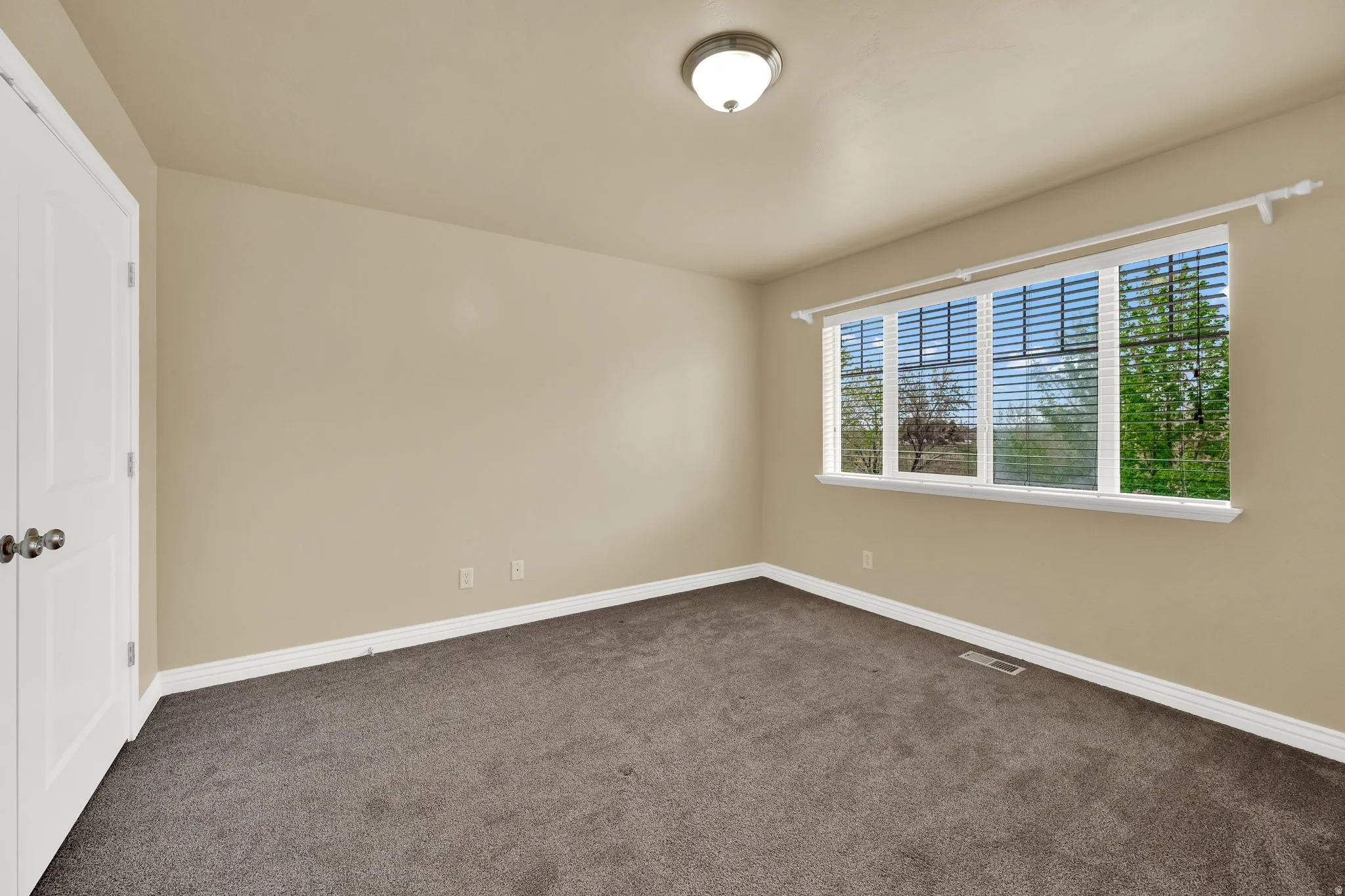 Unfurnished bedroom featuring dark colored carpet and baseboards