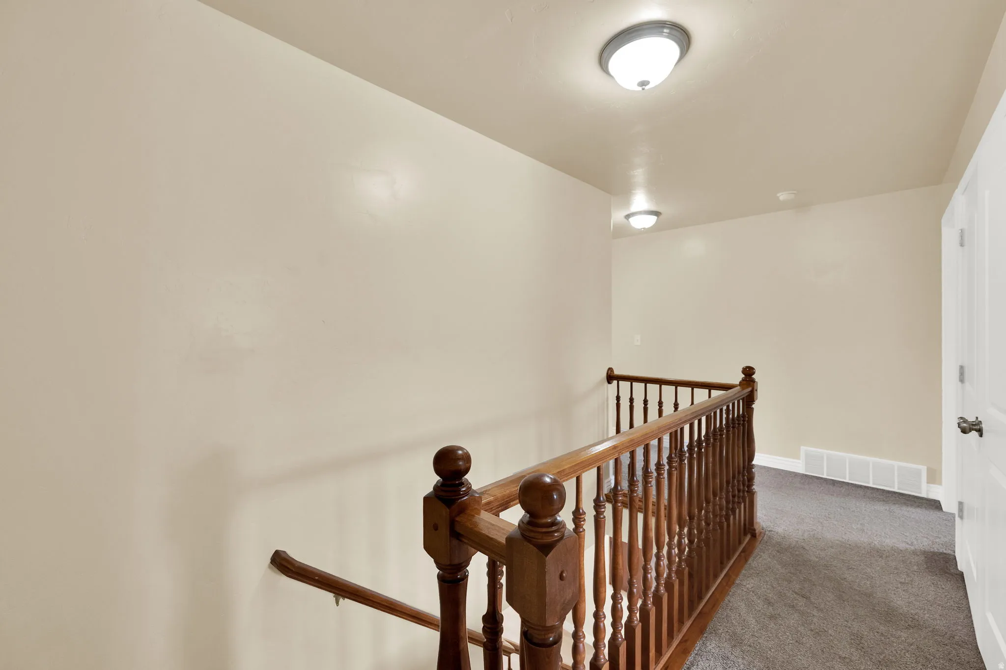 Hall with an upstairs landing and carpet floors