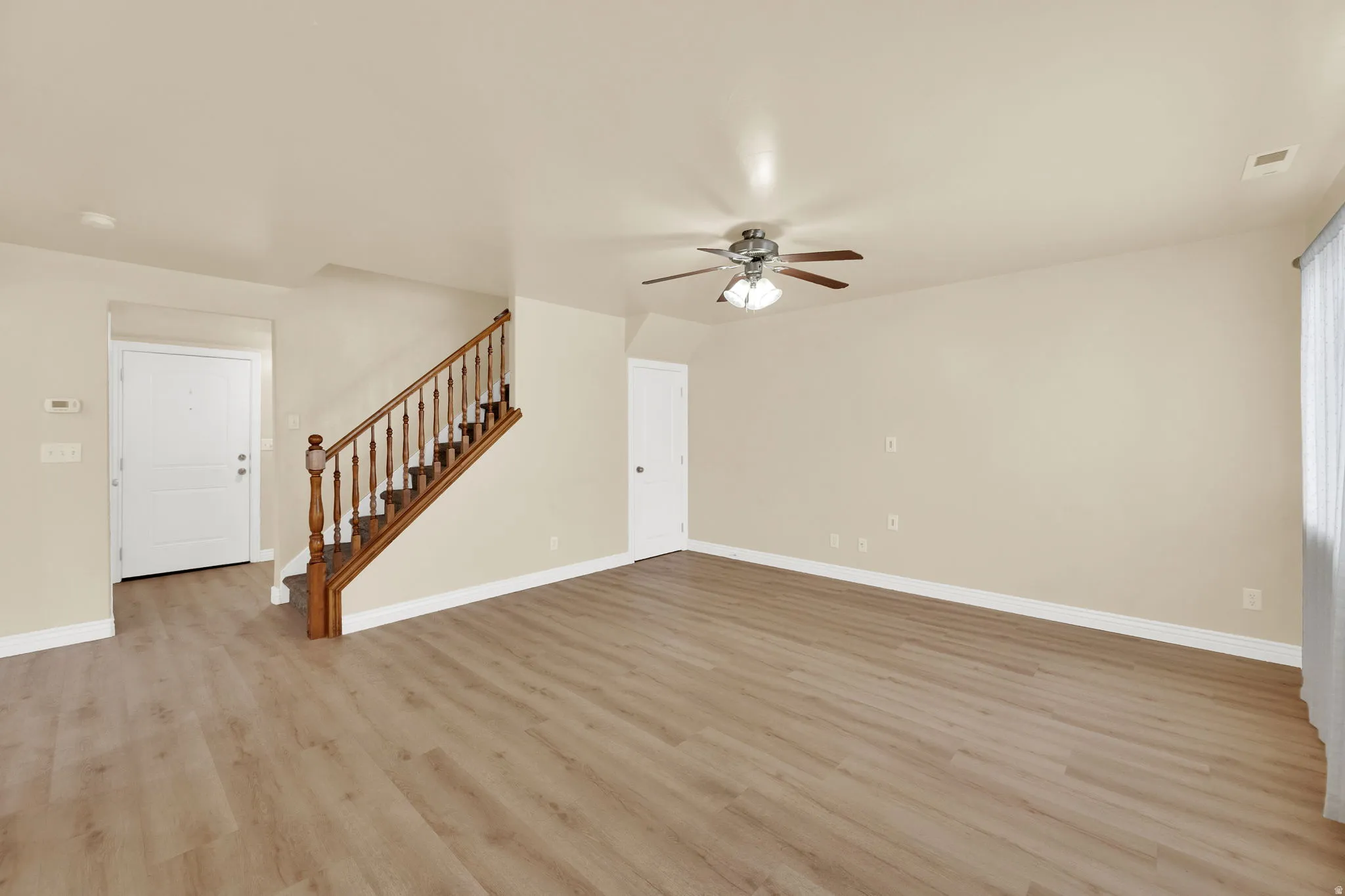 Unfurnished living room with light wood-style flooring and ceiling fan