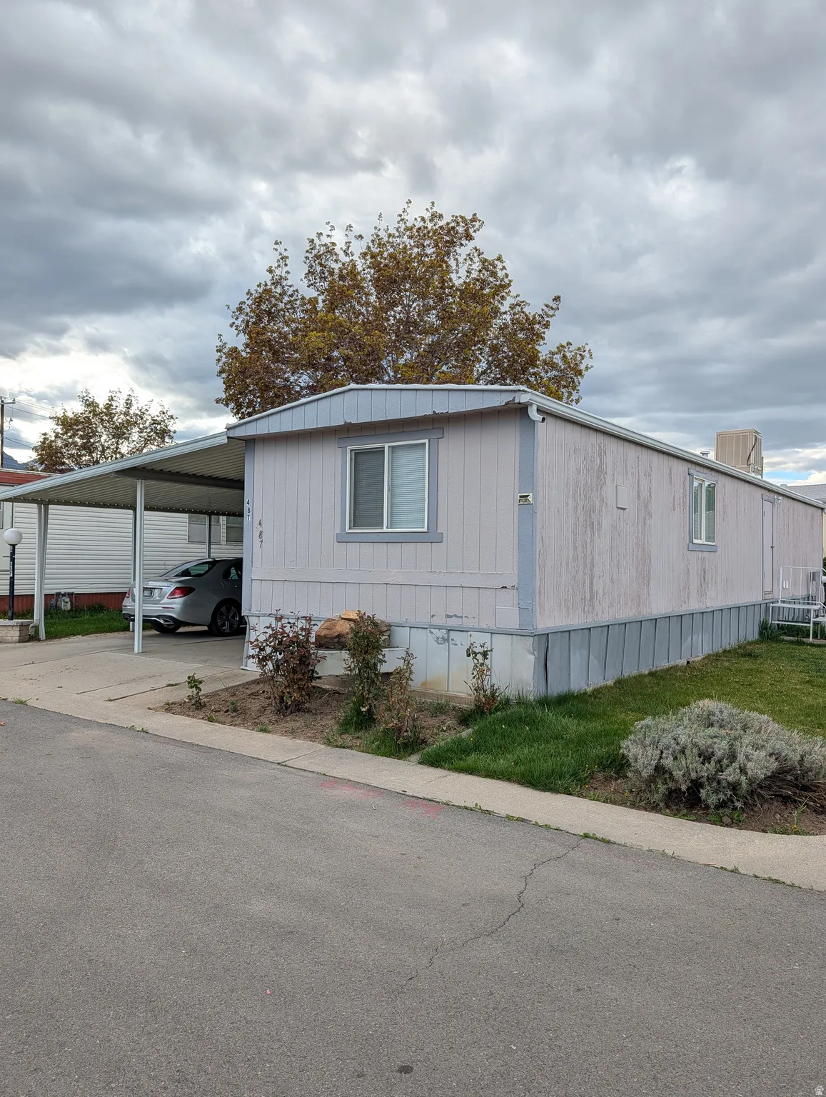 View of side of home featuring an attached carport and concrete driveway
