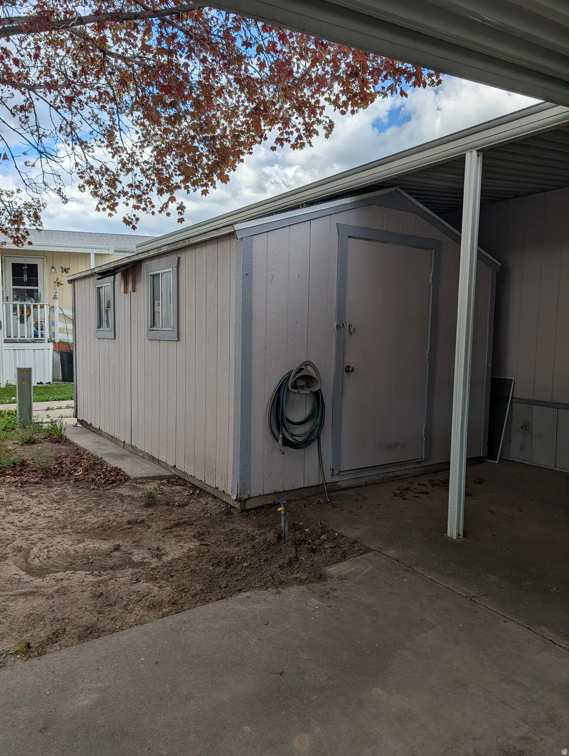 View of side of property featuring a storage shed