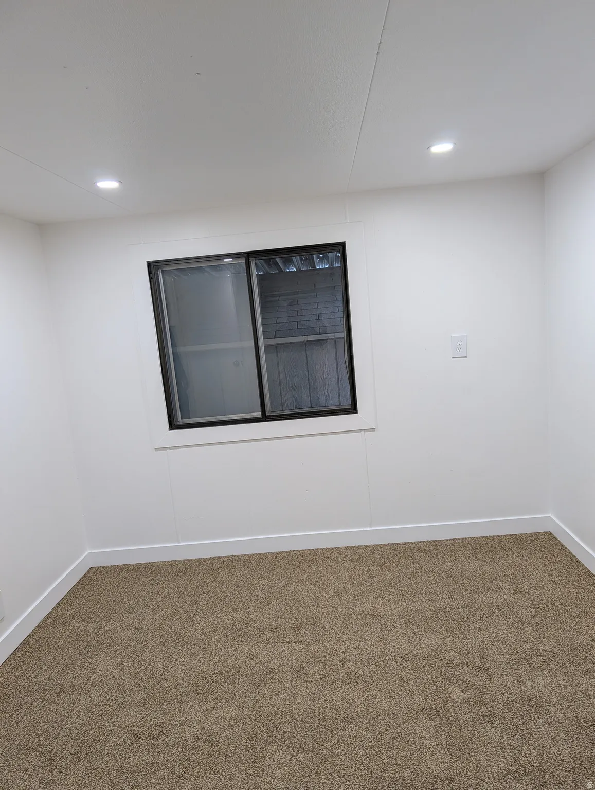 Larger of the two bedrooms, carpeted with recessed lighting