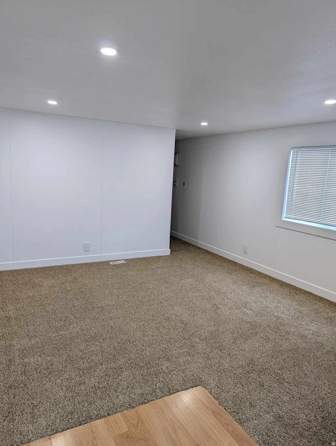 Living Room with recessed lighting and light carpet