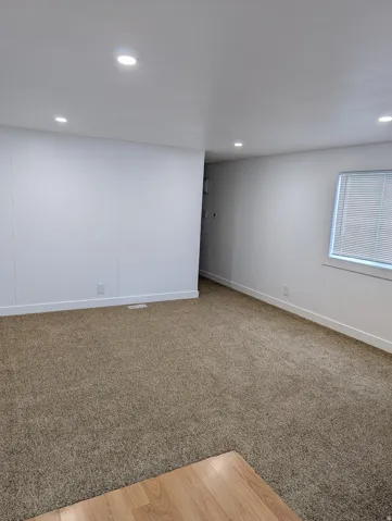 Living Room with recessed lighting and light carpet