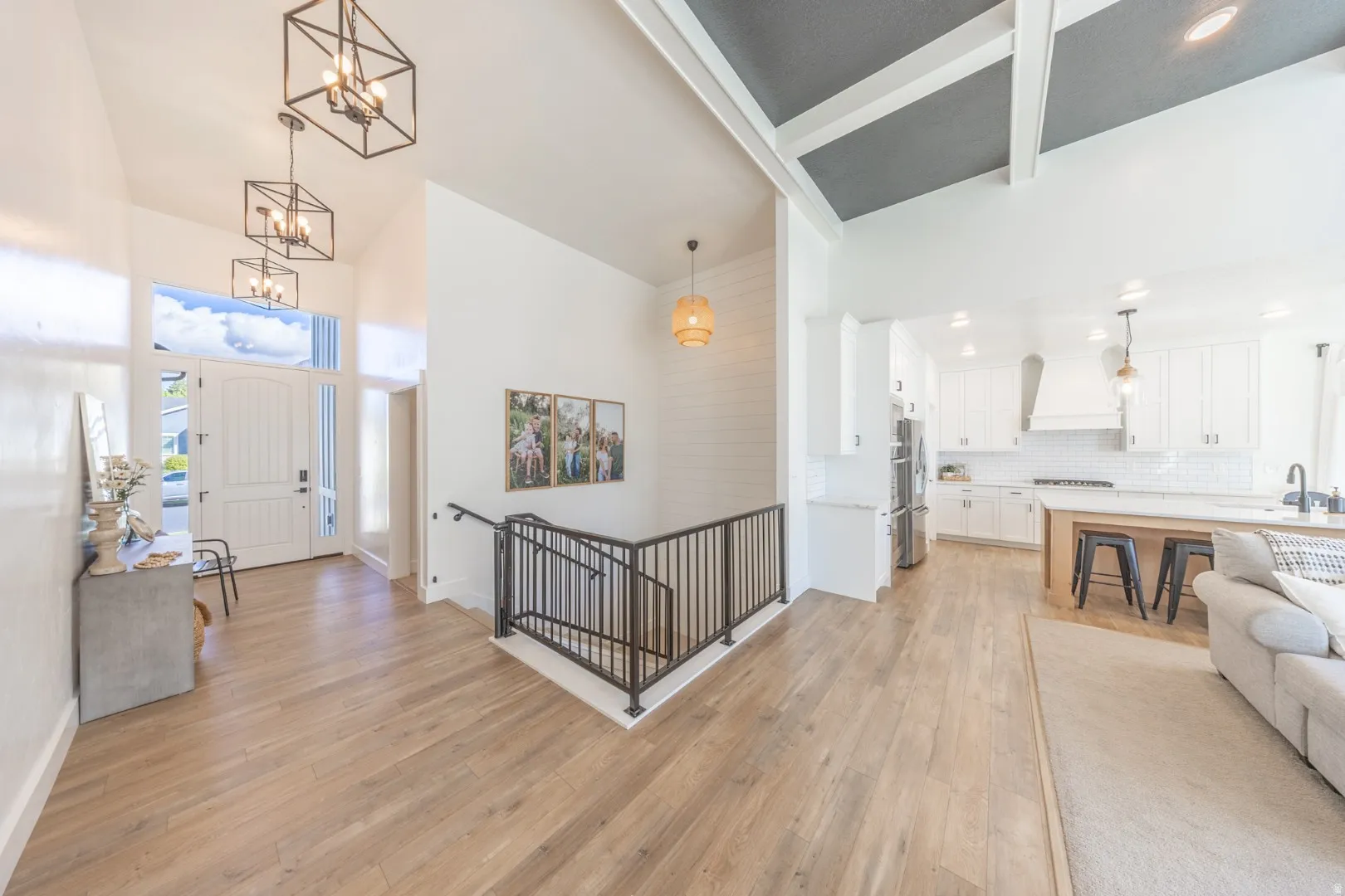 Entrance foyer featuring light wood-style flooring, hanging lights, and vaulted ceiling
