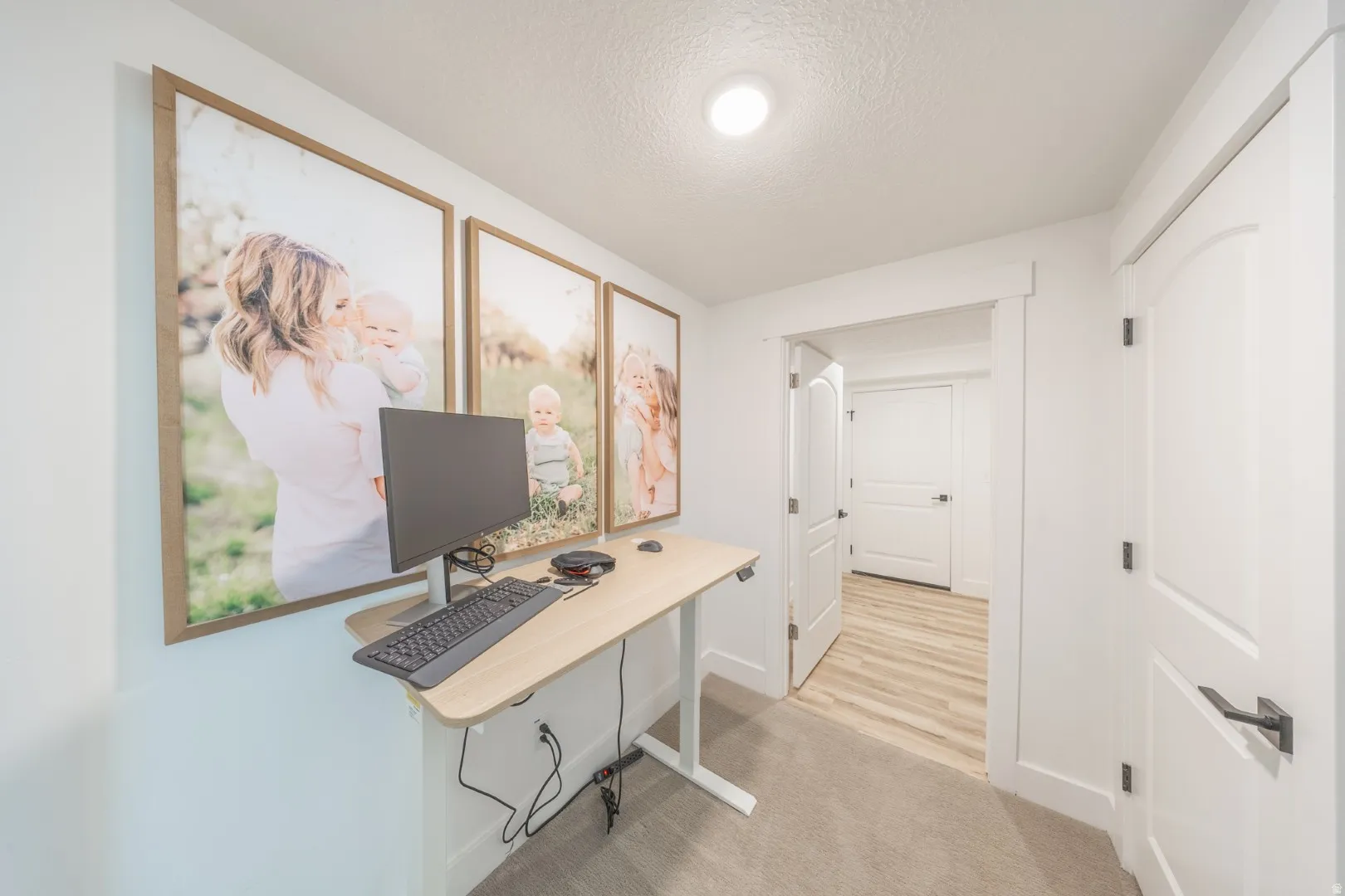Office space with light carpet and a textured ceiling