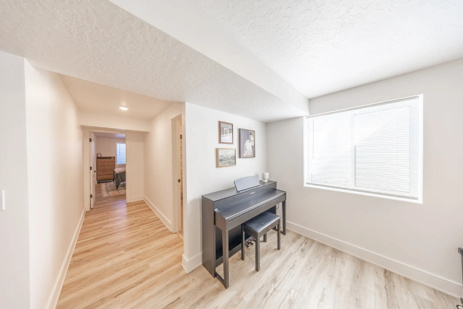 Corridor featuring light wood-style floors and a textured ceiling