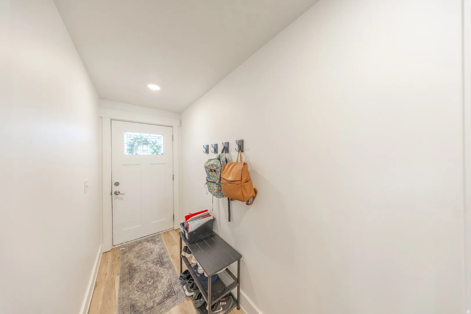 Doorway featuring wood finished floors and recessed lighting