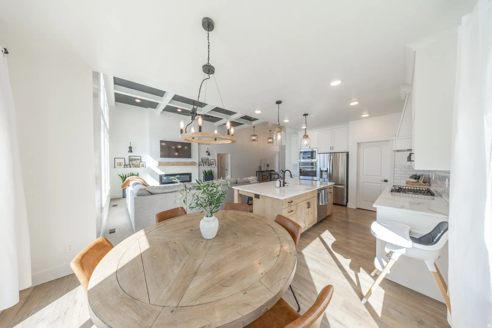Dining room featuring light wood-style flooring, coffered ceiling, and recessed lighting
