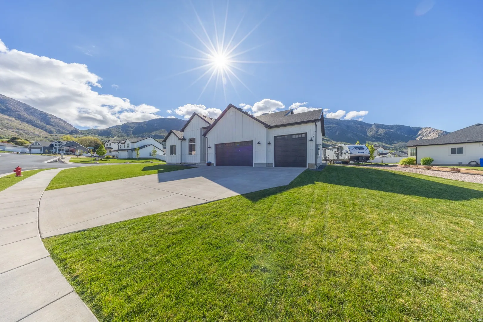 Modern farmhouse featuring a mountain view, a residential view, a garage, and a front yard