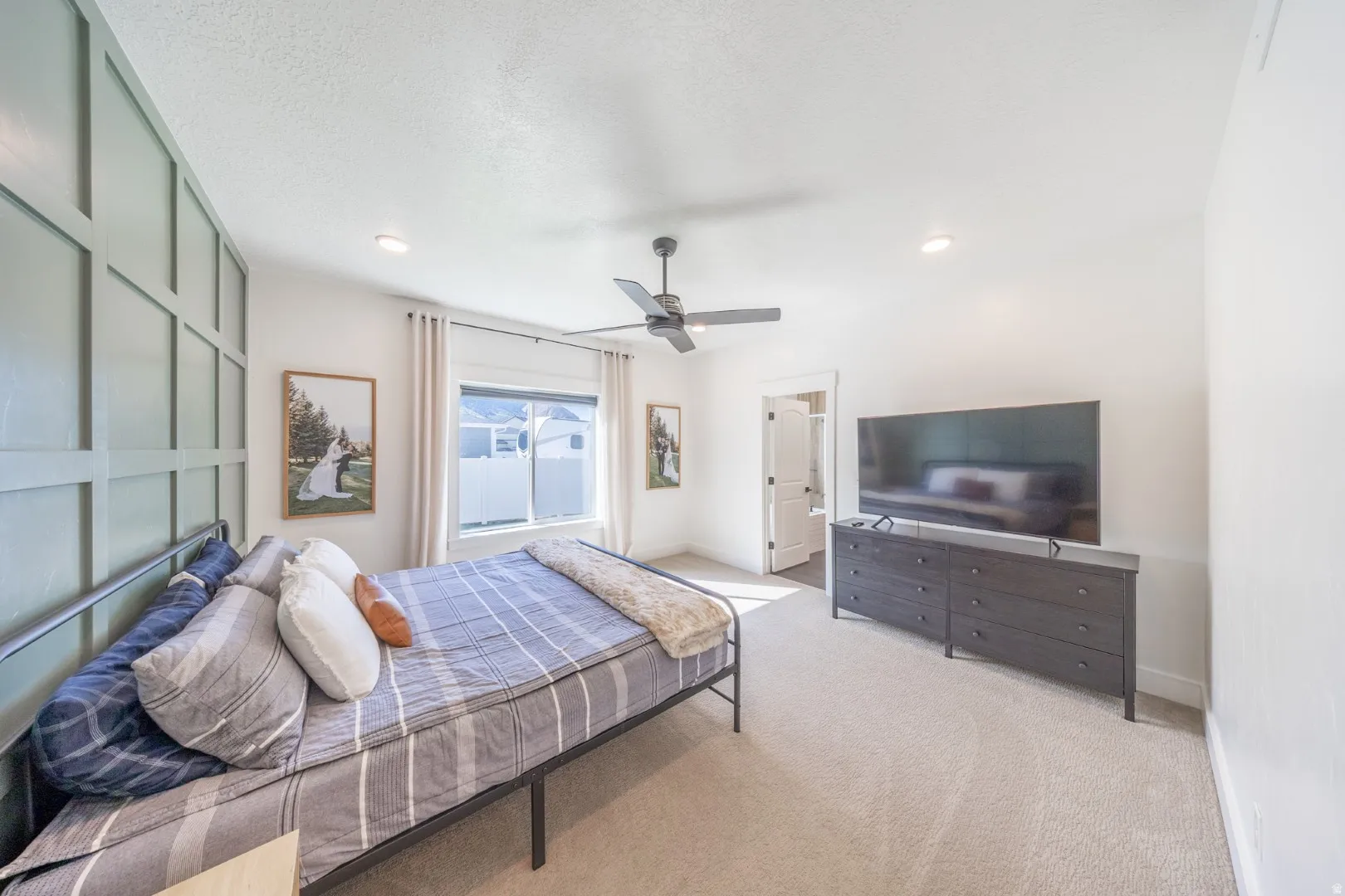 Bedroom featuring light colored carpet and a ceiling fan