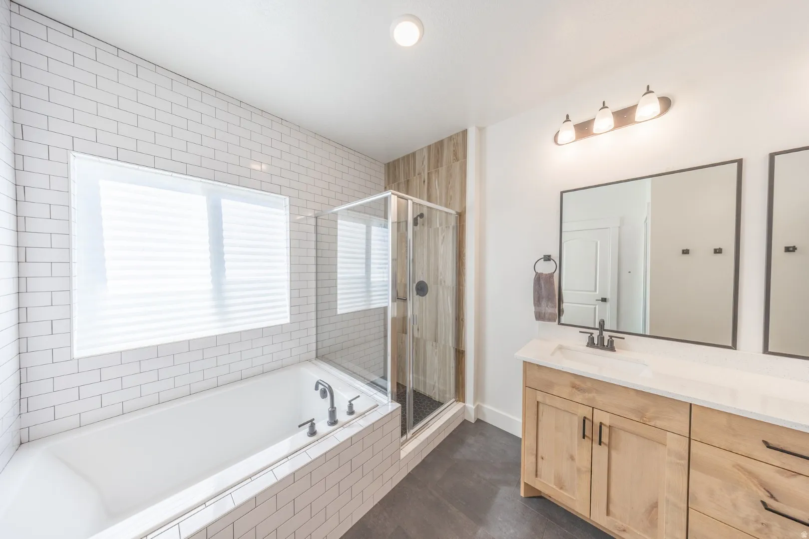 Bathroom with vanity, a stall shower, and a garden tub