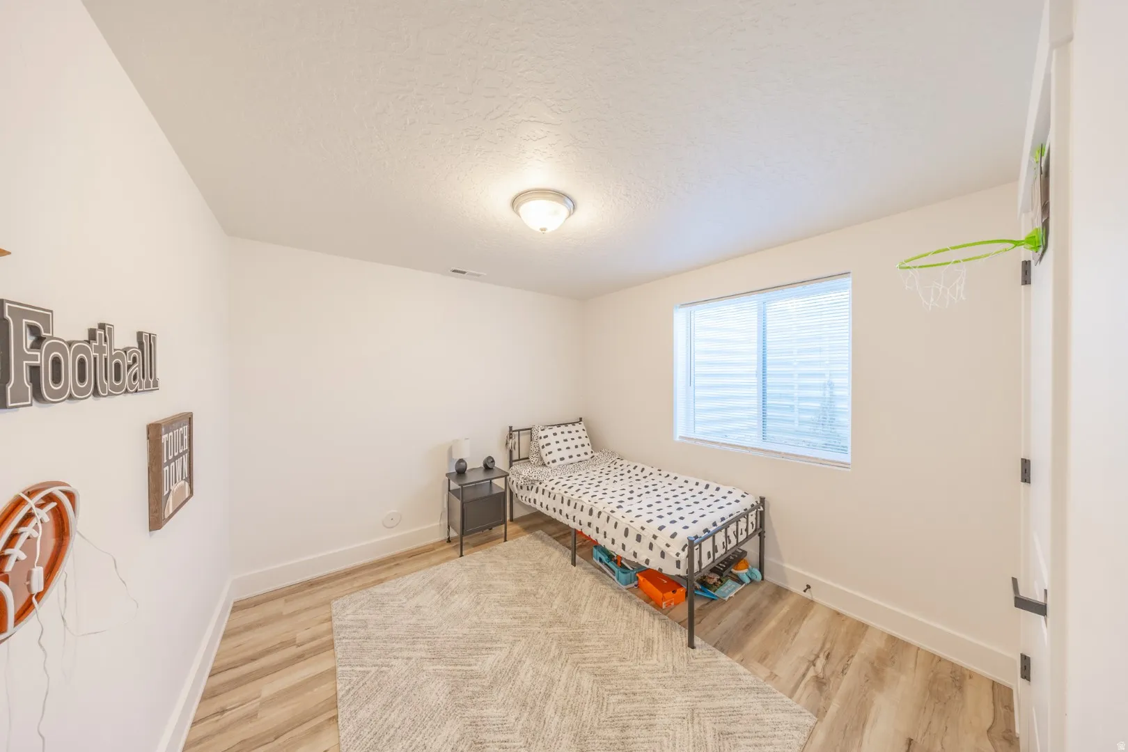 Bedroom featuring light wood finished floors and a textured ceiling
