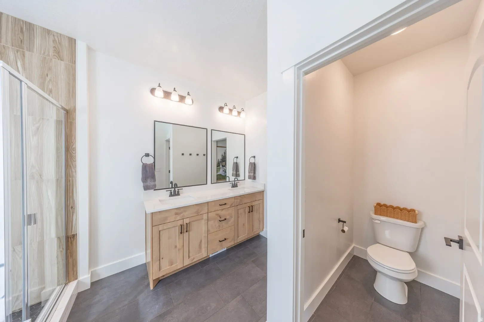Bathroom featuring double vanity and a stall shower