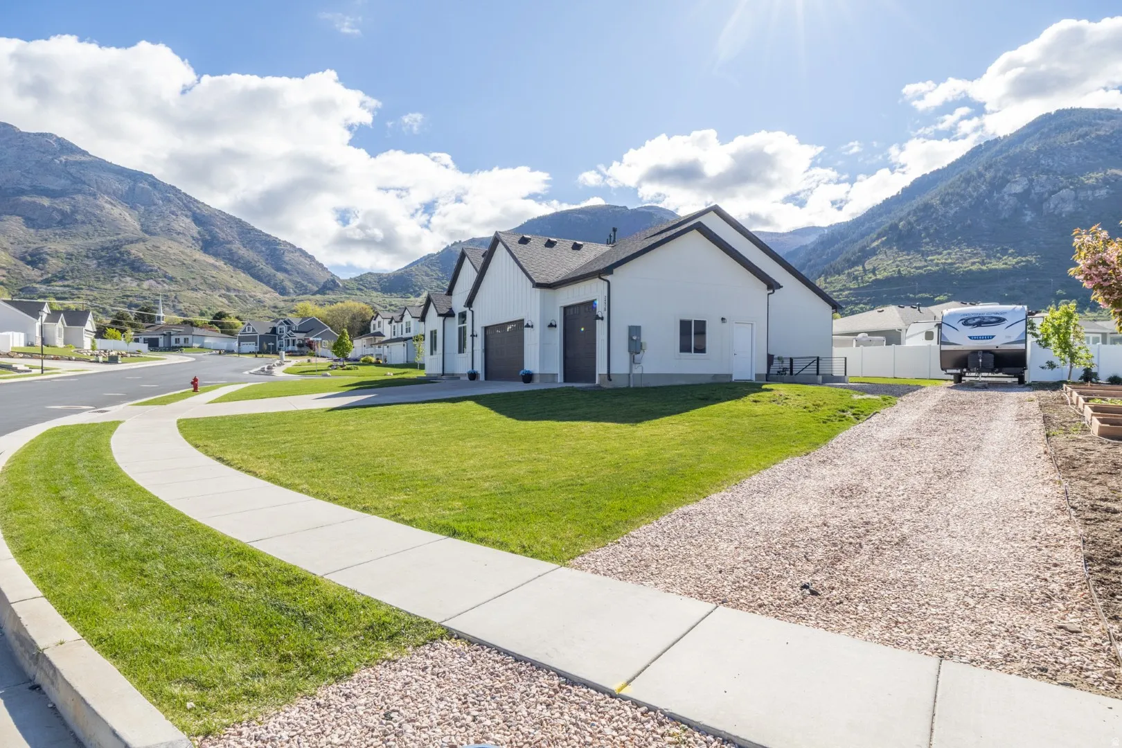 View of front of property with a mountain view, a residential view, driveway, and a garage