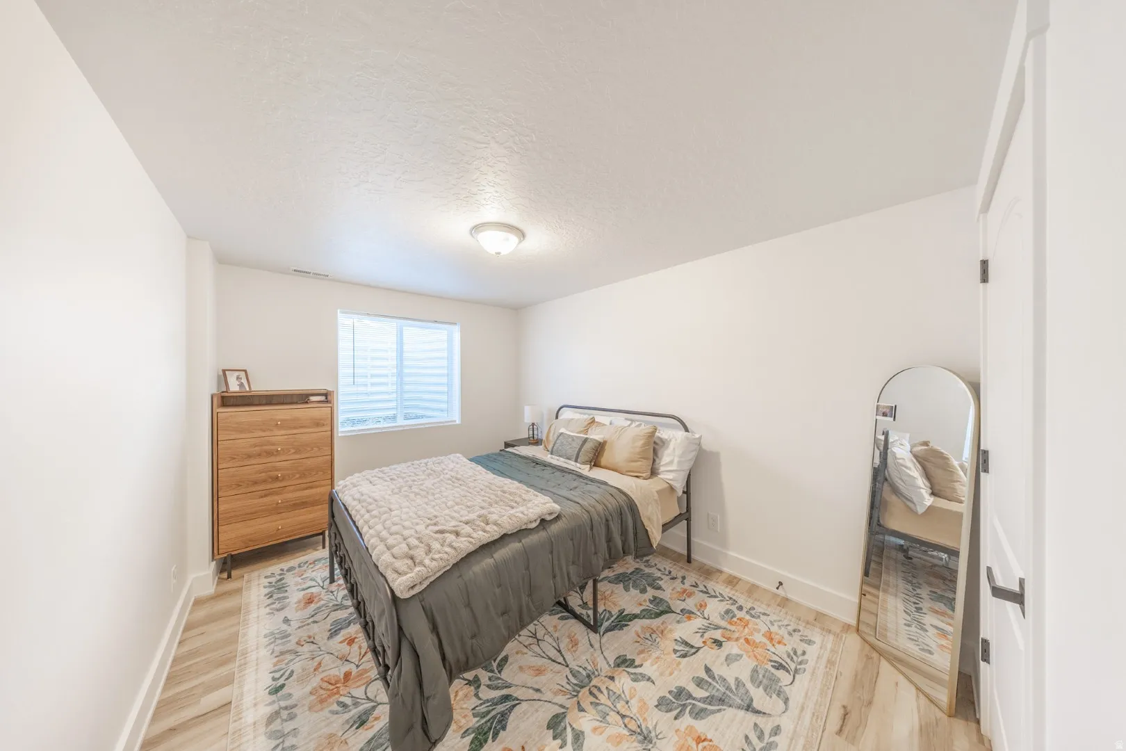 Bedroom with a textured ceiling and light wood finished floors