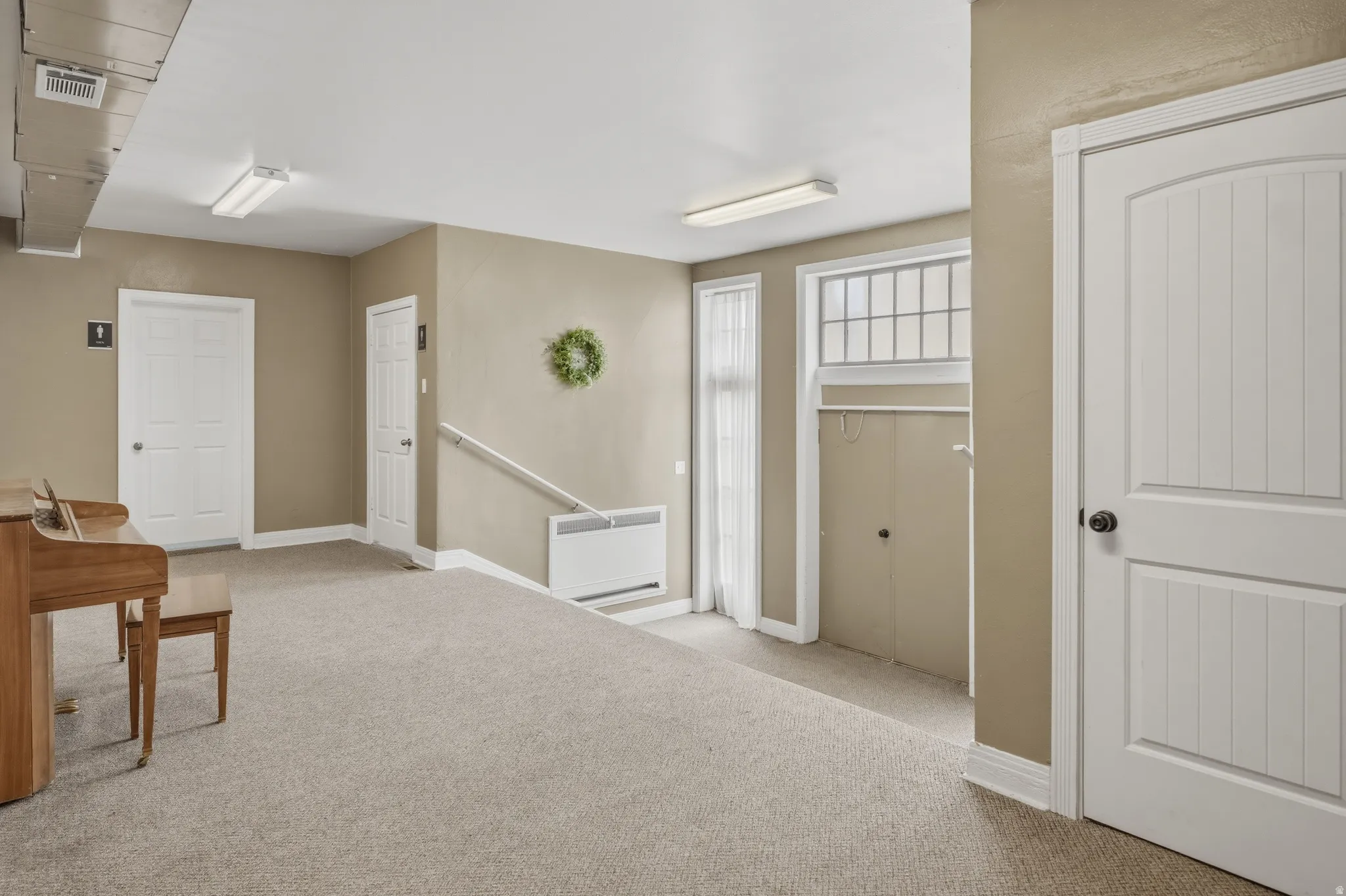 Foyer entrance with light colored carpet and baseboards