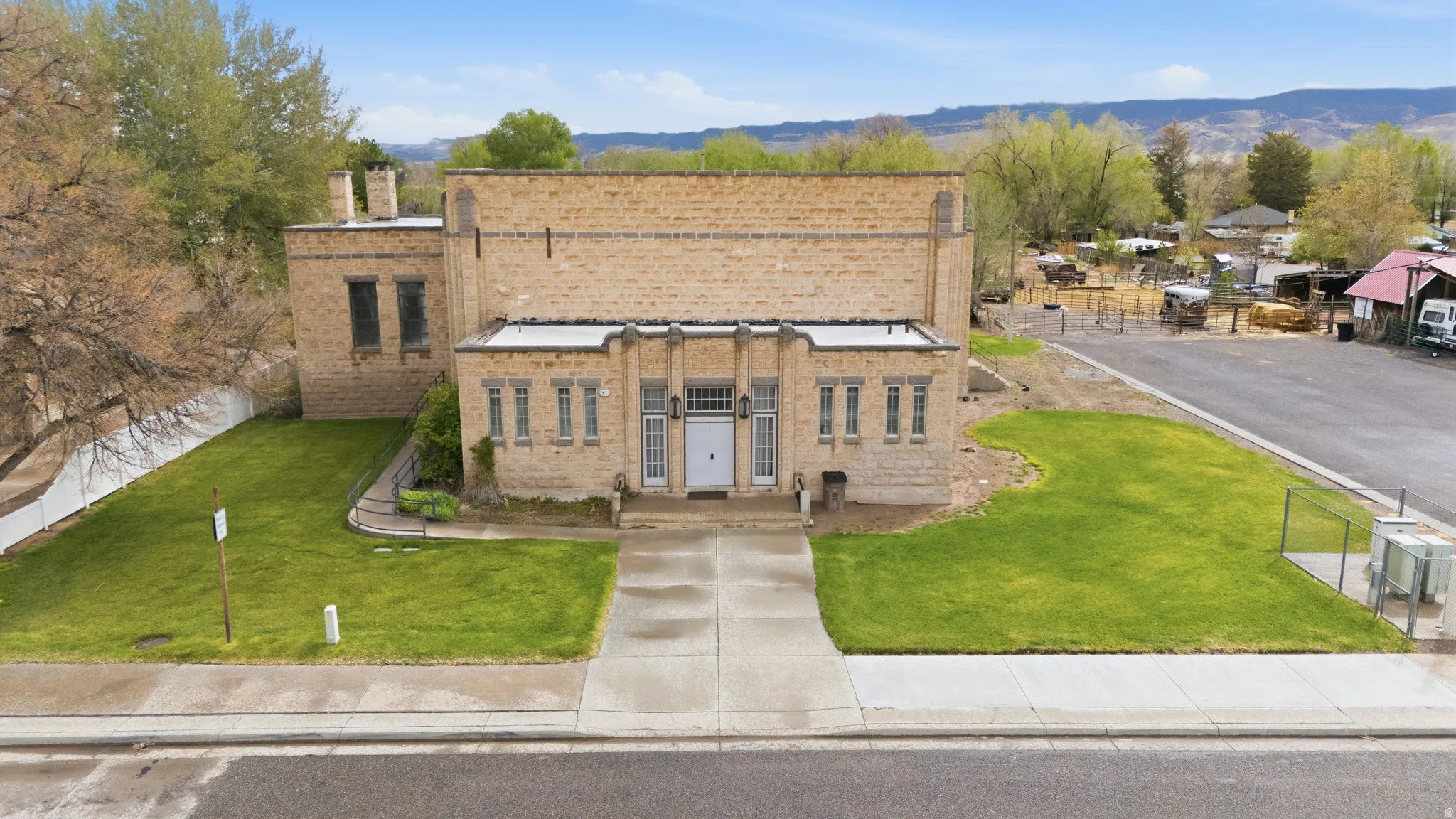 View of front facade with brick siding, a chimney, a front lawn, and a mountain view
