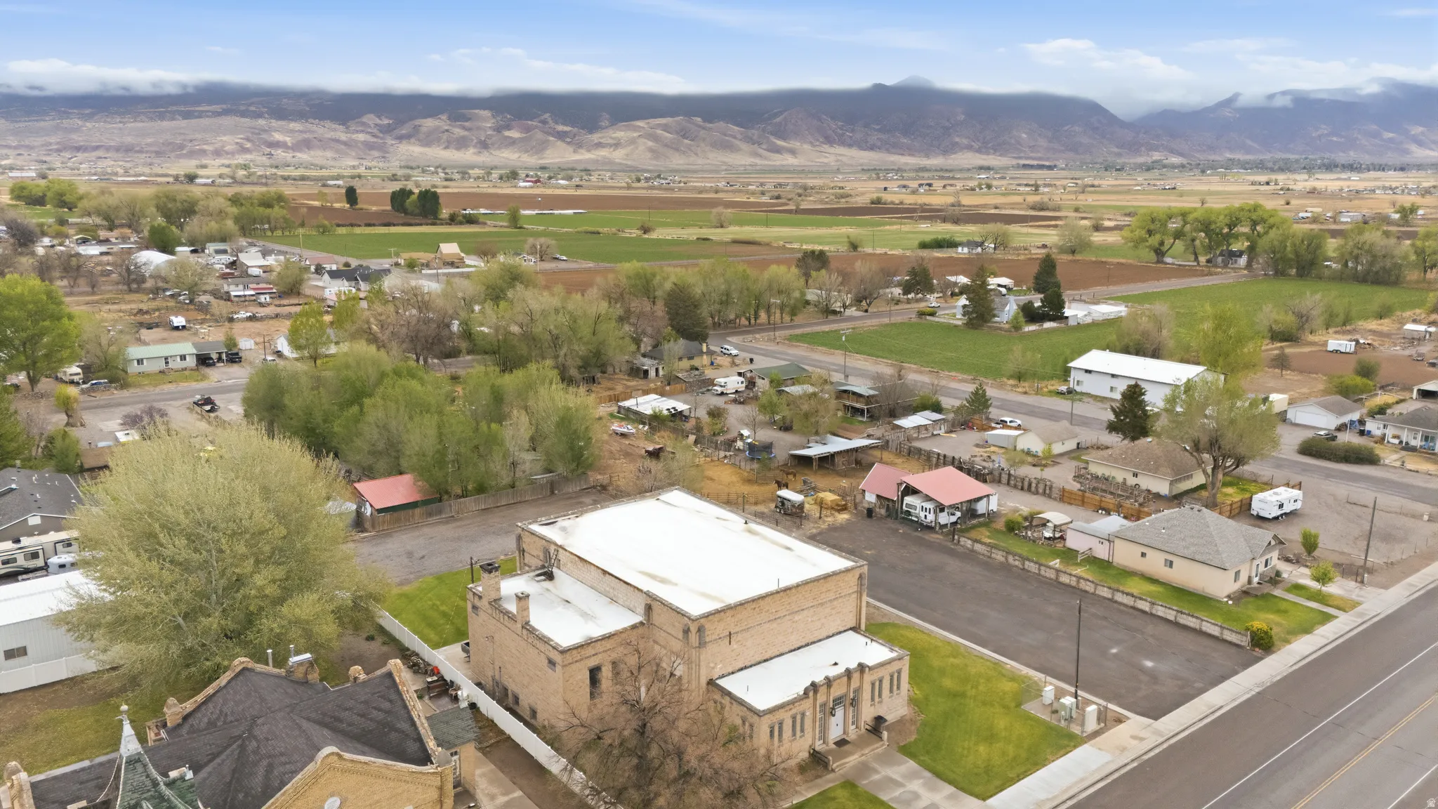 Aerial view of property and surrounding area with nearby suburban area and a mountainous background