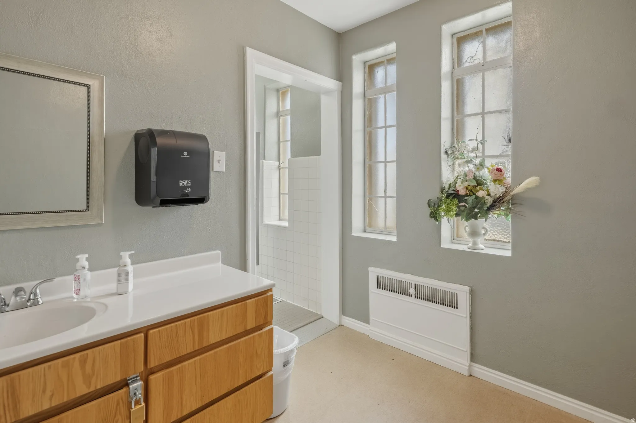 Full bathroom featuring tiled shower and vanity