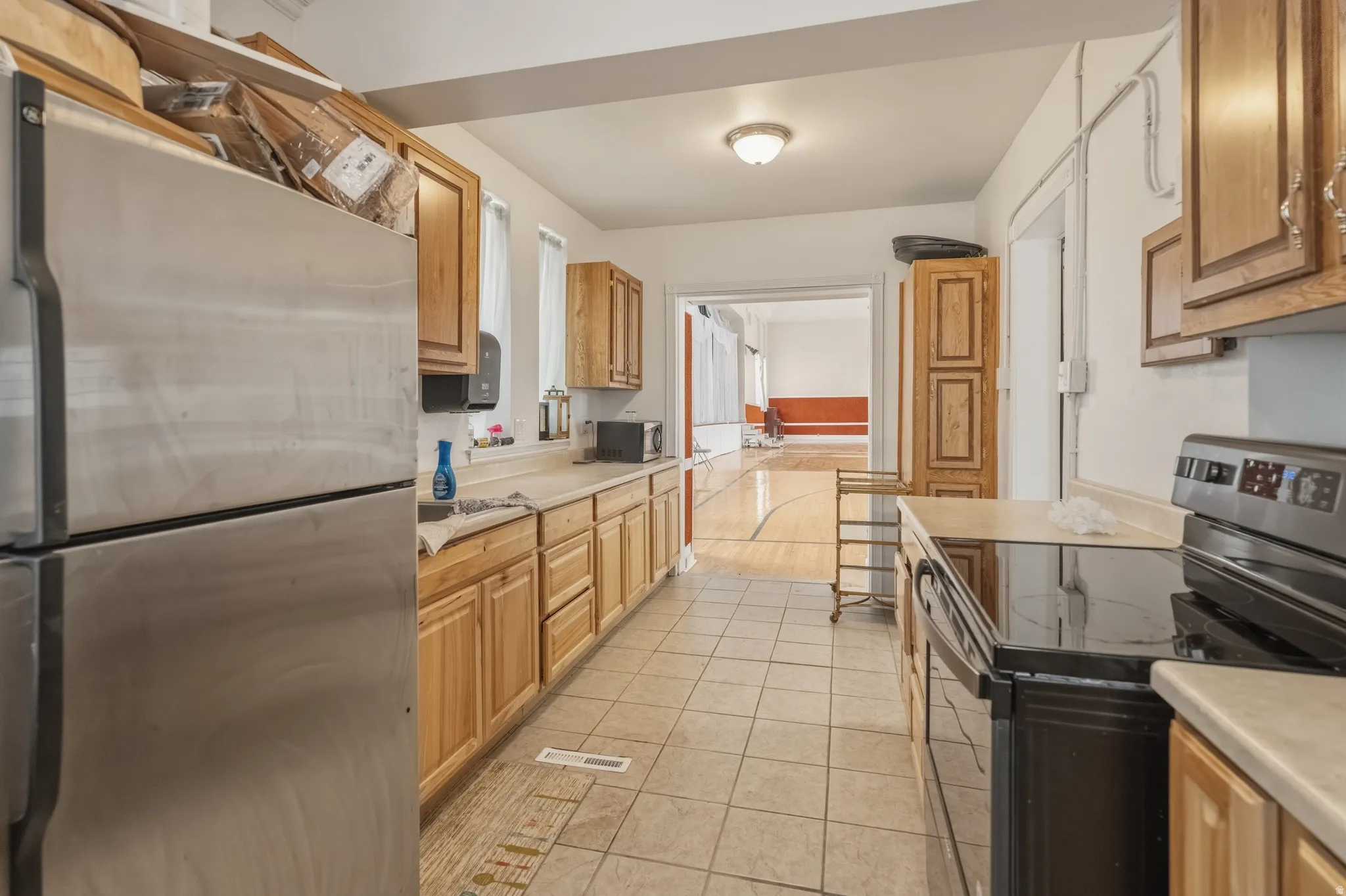 Kitchen featuring stainless steel appliances, light countertops, and light tile patterned flooring