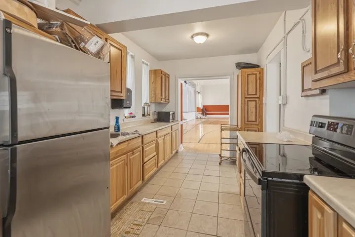 Kitchen featuring stainless steel appliances, light countertops, and light tile patterned flooring