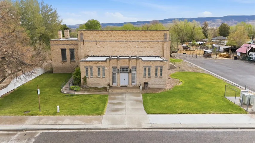 View of front facade with brick siding, a chimney, a front lawn, and a mountain view