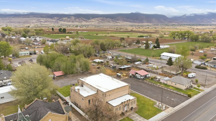 Aerial view of property and surrounding area with nearby suburban area and a mountainous background