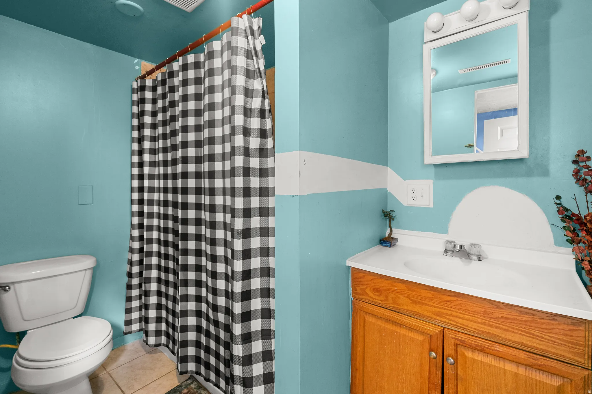 Bathroom featuring vanity, a shower with shower curtain, and light tile patterned flooring