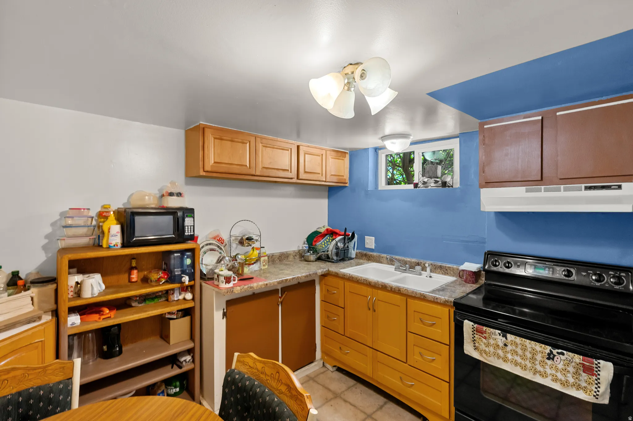 Kitchen featuring black appliances, light countertops, and a ceiling fan