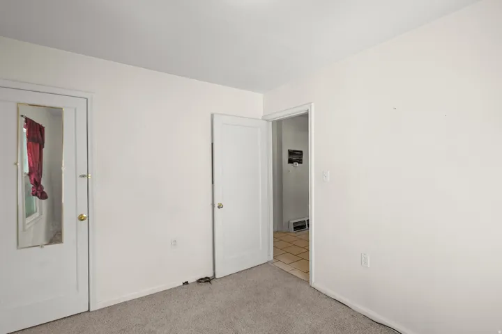 Unfurnished bedroom featuring light colored carpet and baseboards