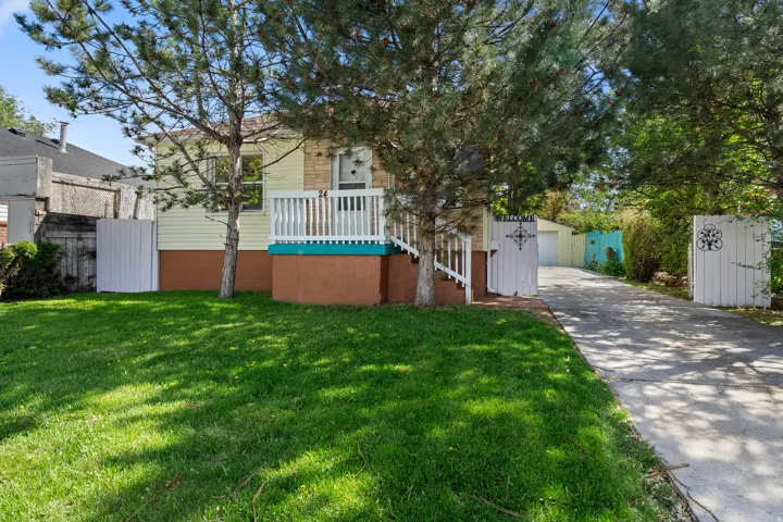 View of front of property with an outdoor structure, a front lawn, and a garage