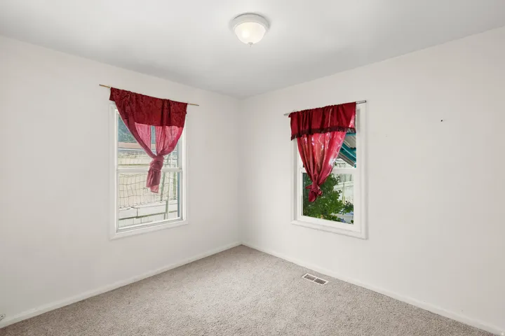 Carpeted spare room featuring baseboards