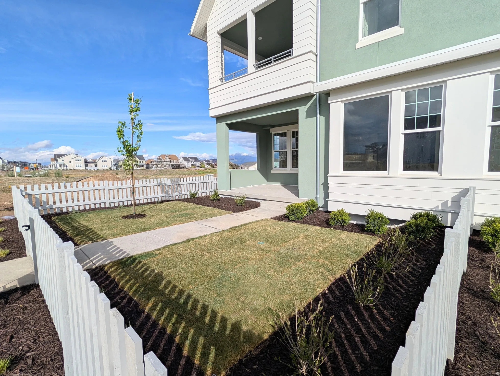 Fenced yard featuring a residential view, a balcony, and a patio area