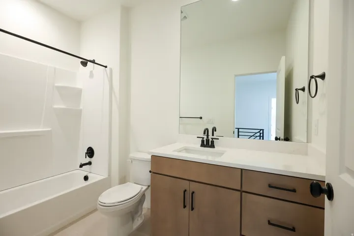 Bathroom featuring vanity, tub / shower combination, and light tile patterned flooring
