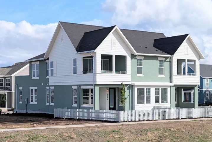 View of front of home featuring a balcony, a fenced front yard, and stucco siding