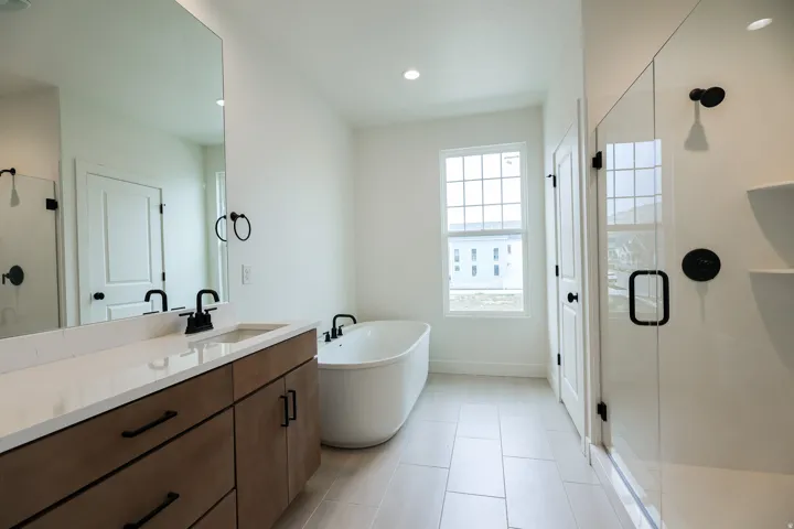 Primary Bathroom with a stall shower, a soaking tub, vanity, recessed lighting, and light tile patterned floors