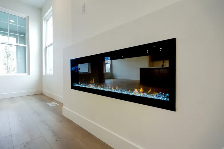 Detailed view of a glass covered fireplace and wood finished floors