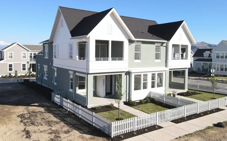 Exterior of home with a balcony, stucco siding, and a fenced front yard