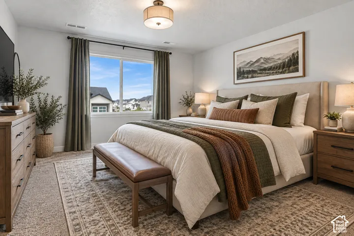Wall-to-wall carpeting and a large window with vertical blinds