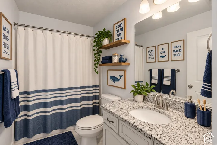 Bathroom featuring a single vanity with stone-finish countertop, undermount sink, and brushed nickel faucet