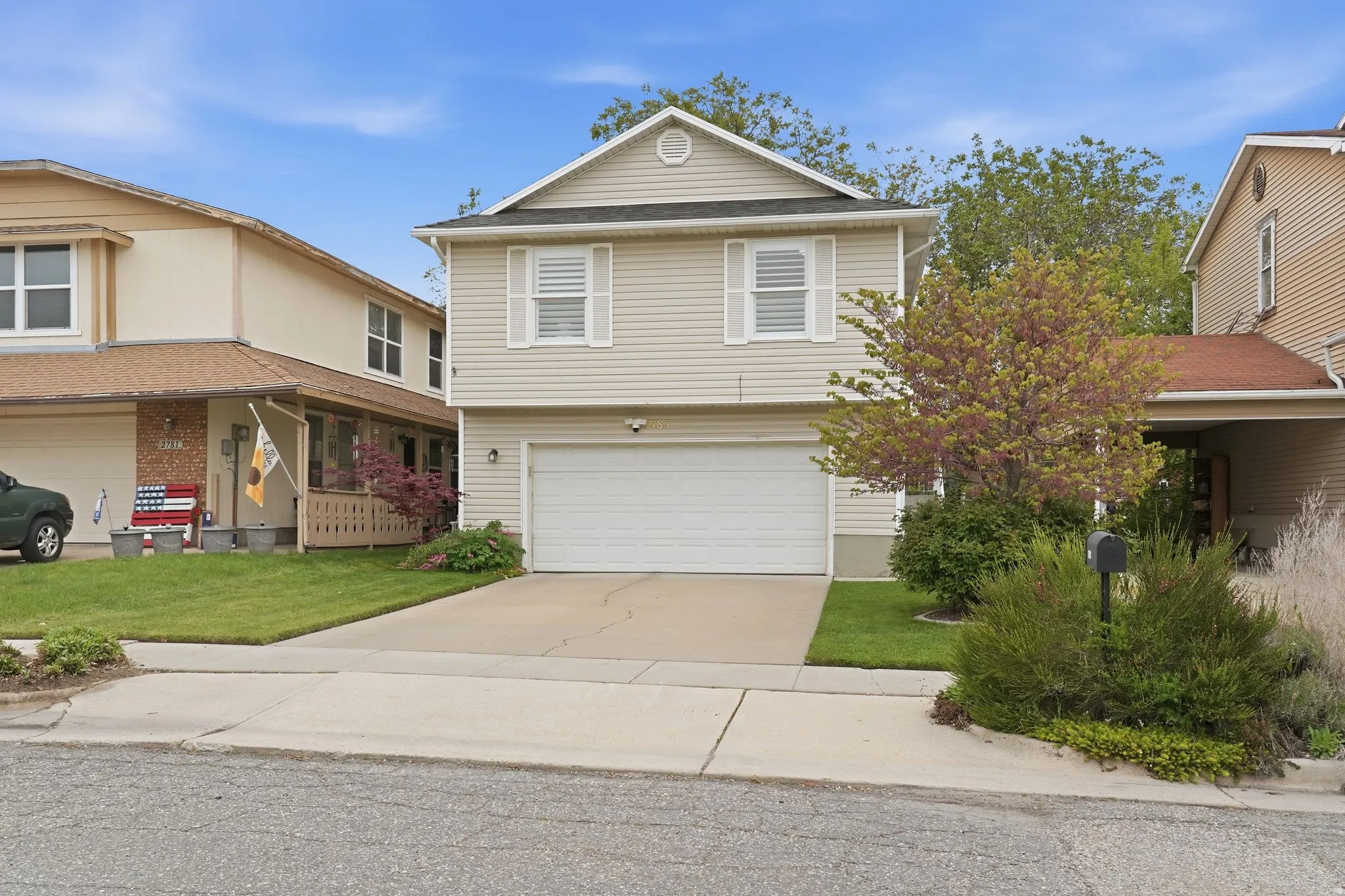 View of front facade with driveway, a garage, and a front lawn