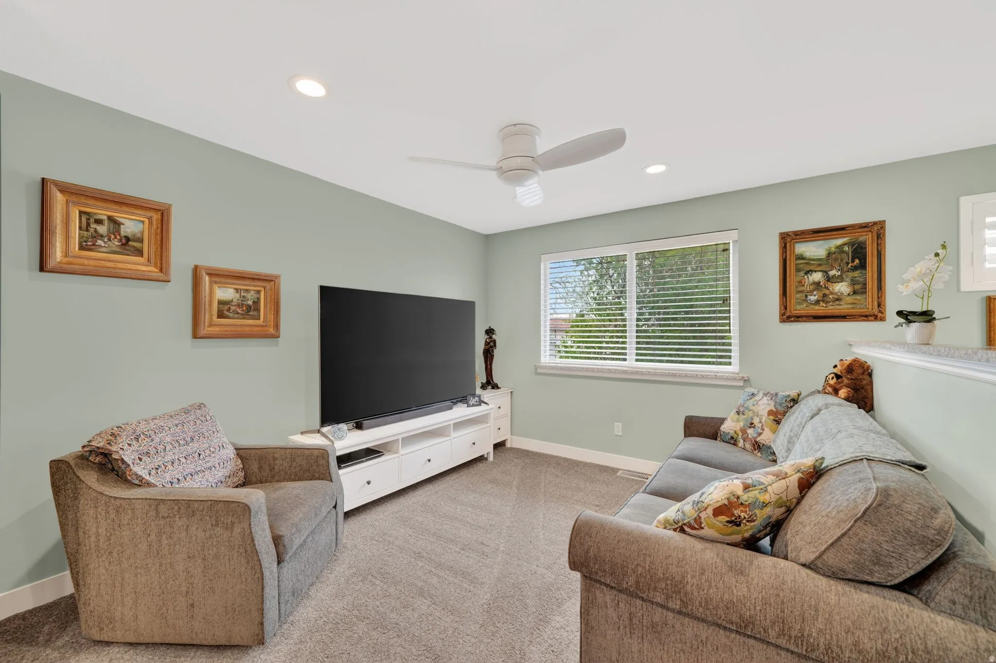 Living area with light carpet, recessed lighting, and a ceiling fan
